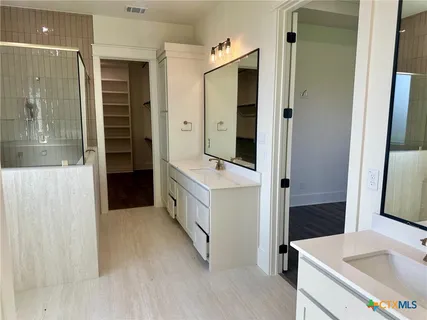 a bathroom with a tub sink and mirror