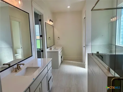 a bathroom with a tub sink shower and mirror