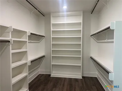 a view of walk in closet with empty racks