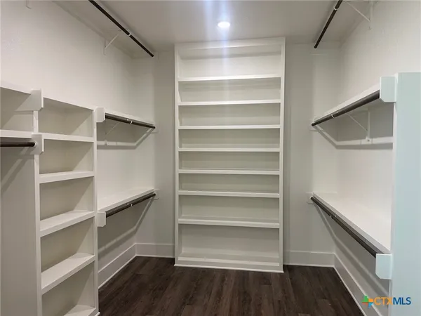 a view of walk in closet with empty racks