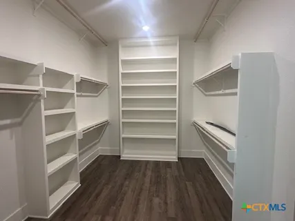 a view of walk in closet with empty racks