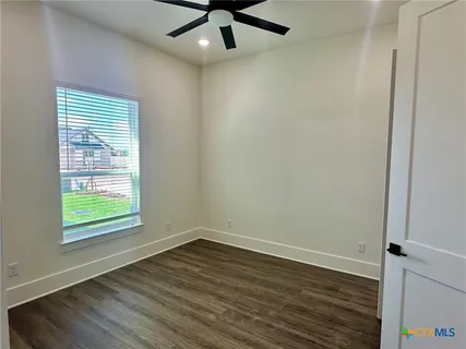 an empty room with wooden floor and closet area