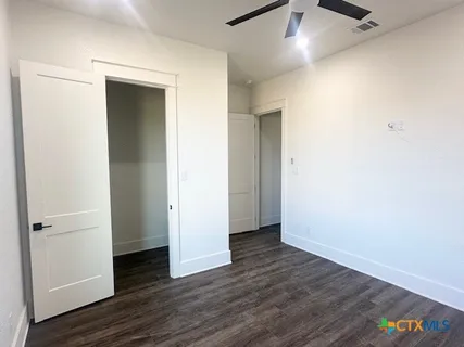 an empty room with wooden floor and closet