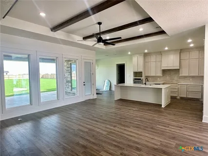 a view of kitchen with kitchen island wooden floor center island and stainless steel appliances