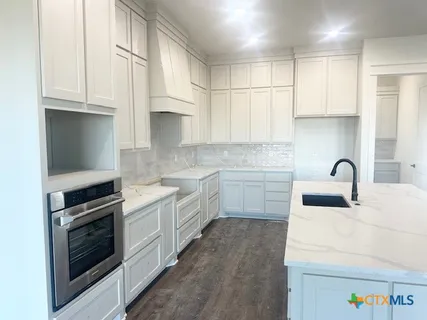 a kitchen with white cabinets stainless steel appliances and sink