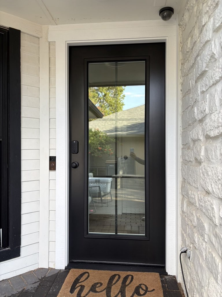 16725 Whitebrush Loop Austin, TX 78717 - Photo 29 of 32 An elegant glass-paneled entryway showcases a modern electronic smart lock framed by stone accents.