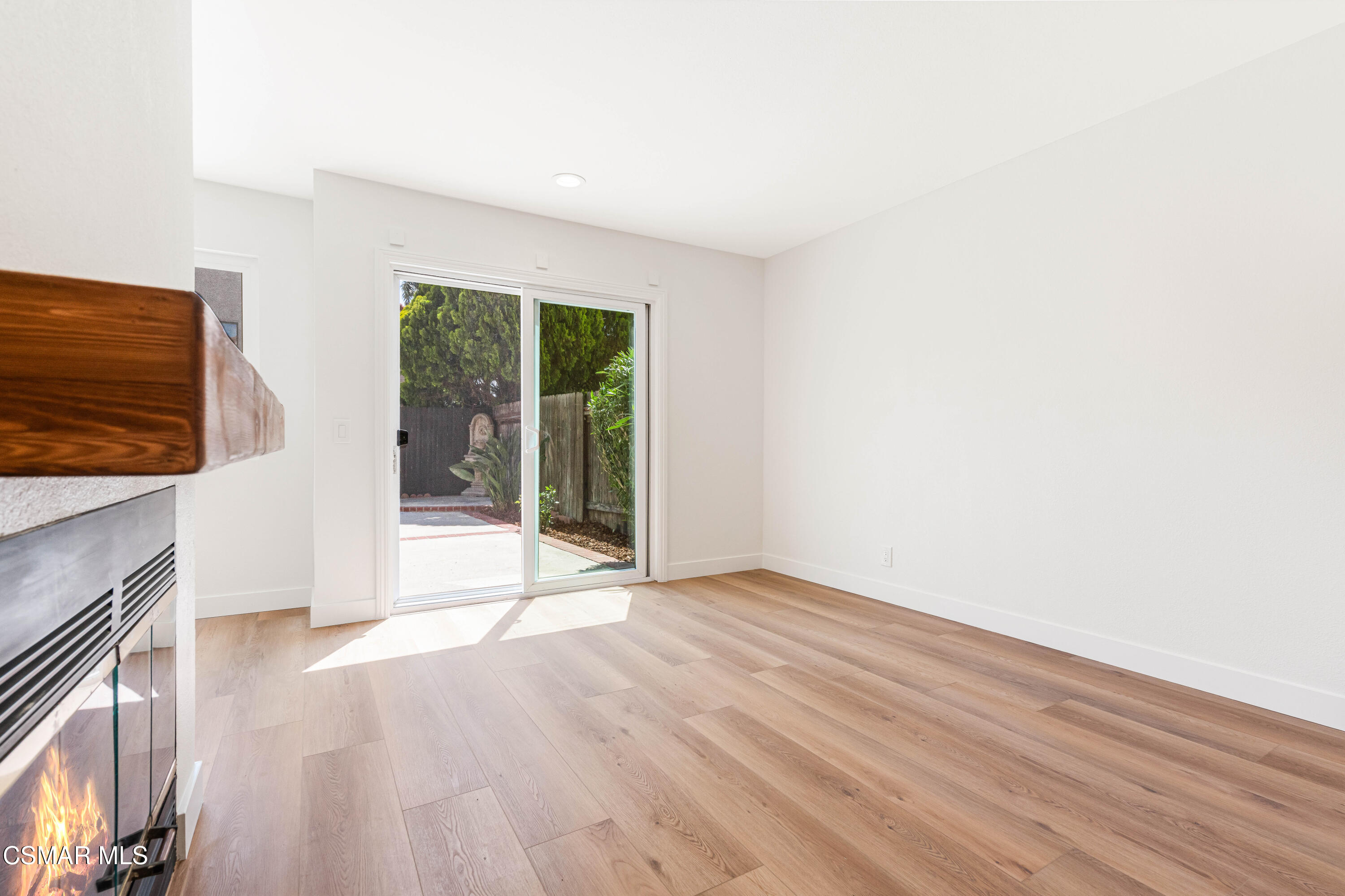 2332 Hampton Avenue Simi Valley, CA 93063 - Photo 15 of 34 a view of an empty room with wooden floor and a fireplace
