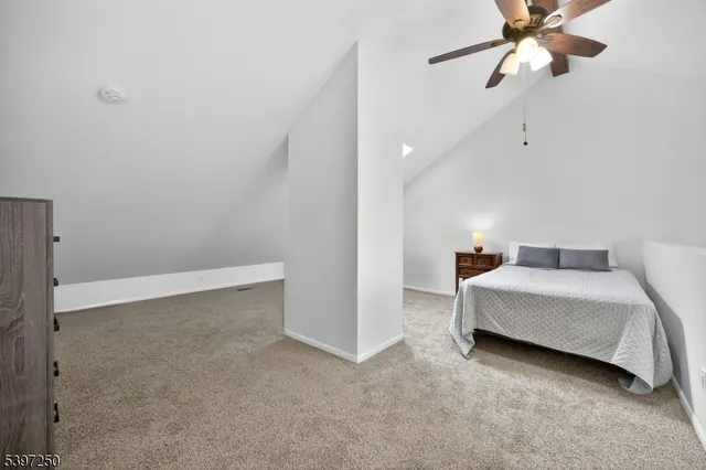 a spacious bedroom with a bed and a ceiling fan