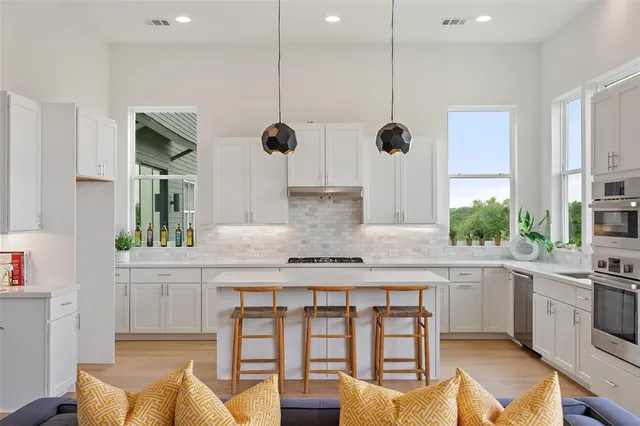 a kitchen with stainless steel appliances granite countertop a stove a sink and a refrigerator