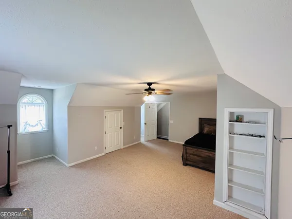 a spacious bedroom with a bed and a chandelier