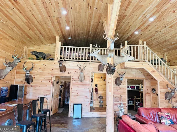 a dining hall with stainless steel appliances kitchen island granite countertop a table chairs and a refrigerator