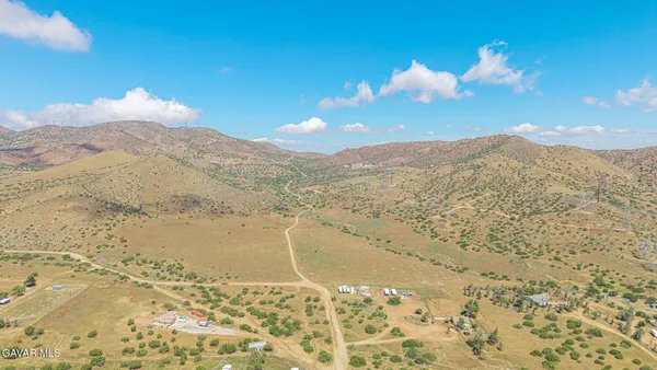 a view of a dry yard with mountains in the background