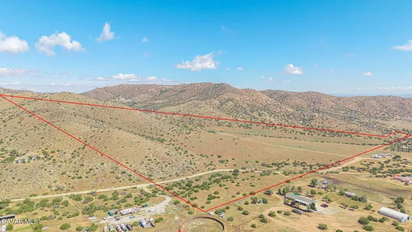 a view of a dry yard with mountains in the background