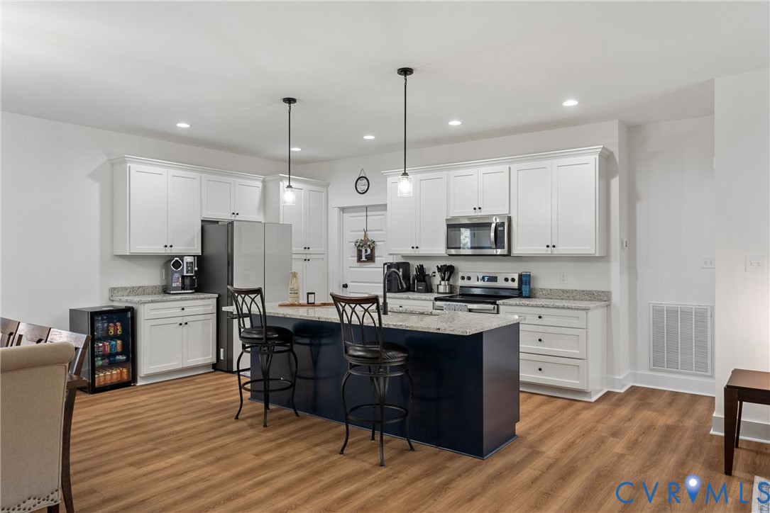 4316 Mt Airy Road Louisa, VA 23093 - Photo 14 of 45 a kitchen with kitchen island granite countertop a sink cabinets and wooden floor