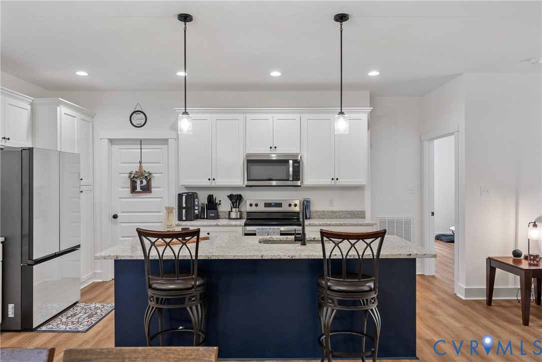 4316 Mt Airy Road Louisa, VA 23093 - Photo 15 of 45 a kitchen with stainless steel appliances granite countertop a stove top oven a refrigerator a sink and chairs