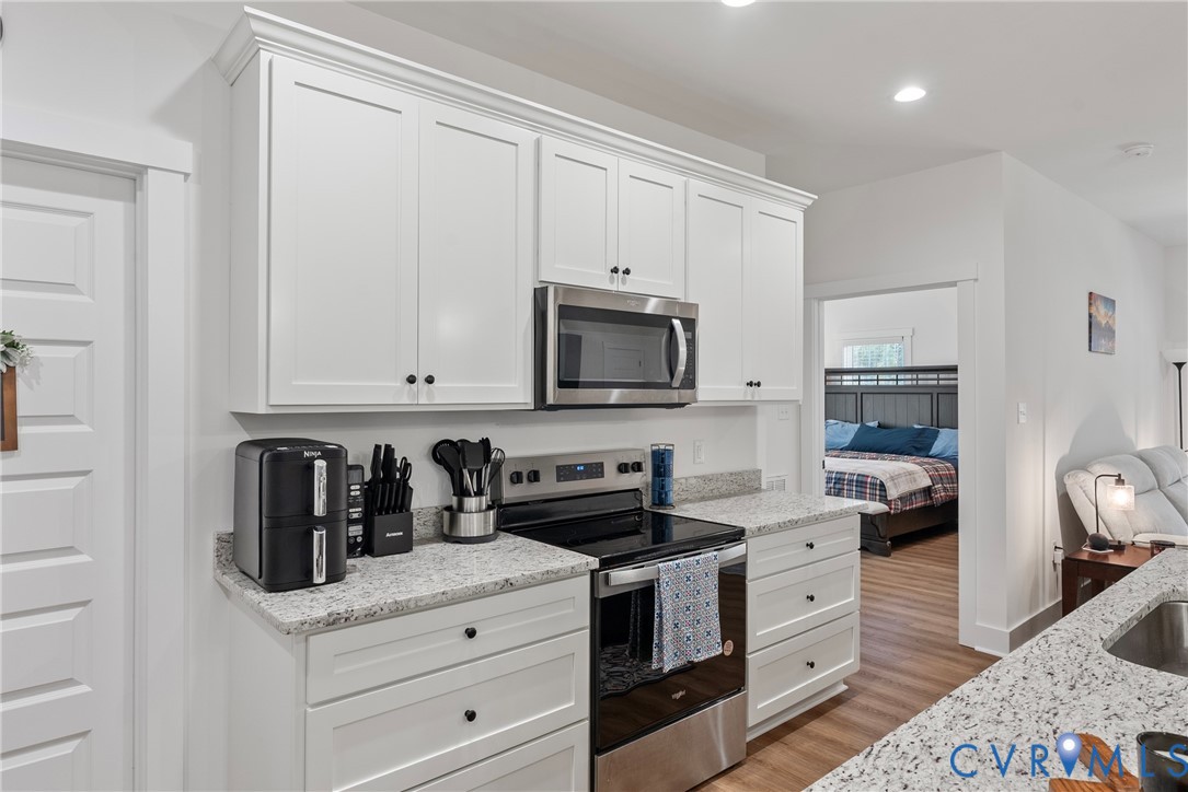 4316 Mt Airy Road Louisa, VA 23093 - Photo 18 of 45 a kitchen with white cabinets and black appliances