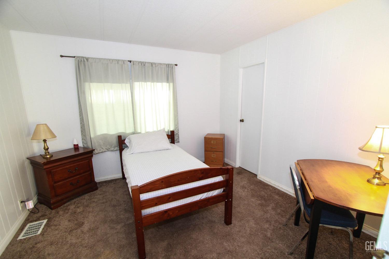 Undisclosed Address Bakersfield, CA 93301 - Photo 16 of 27 a bedroom with a bed and a desk