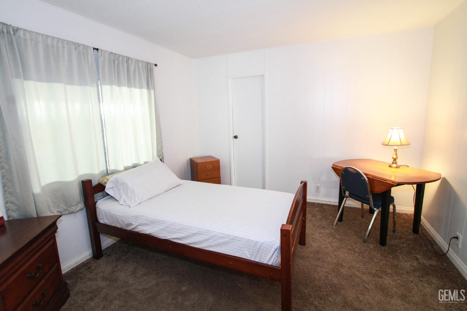 Undisclosed Address Bakersfield, CA 93301 - Photo 17 of 27 a bedroom with a bed and a table