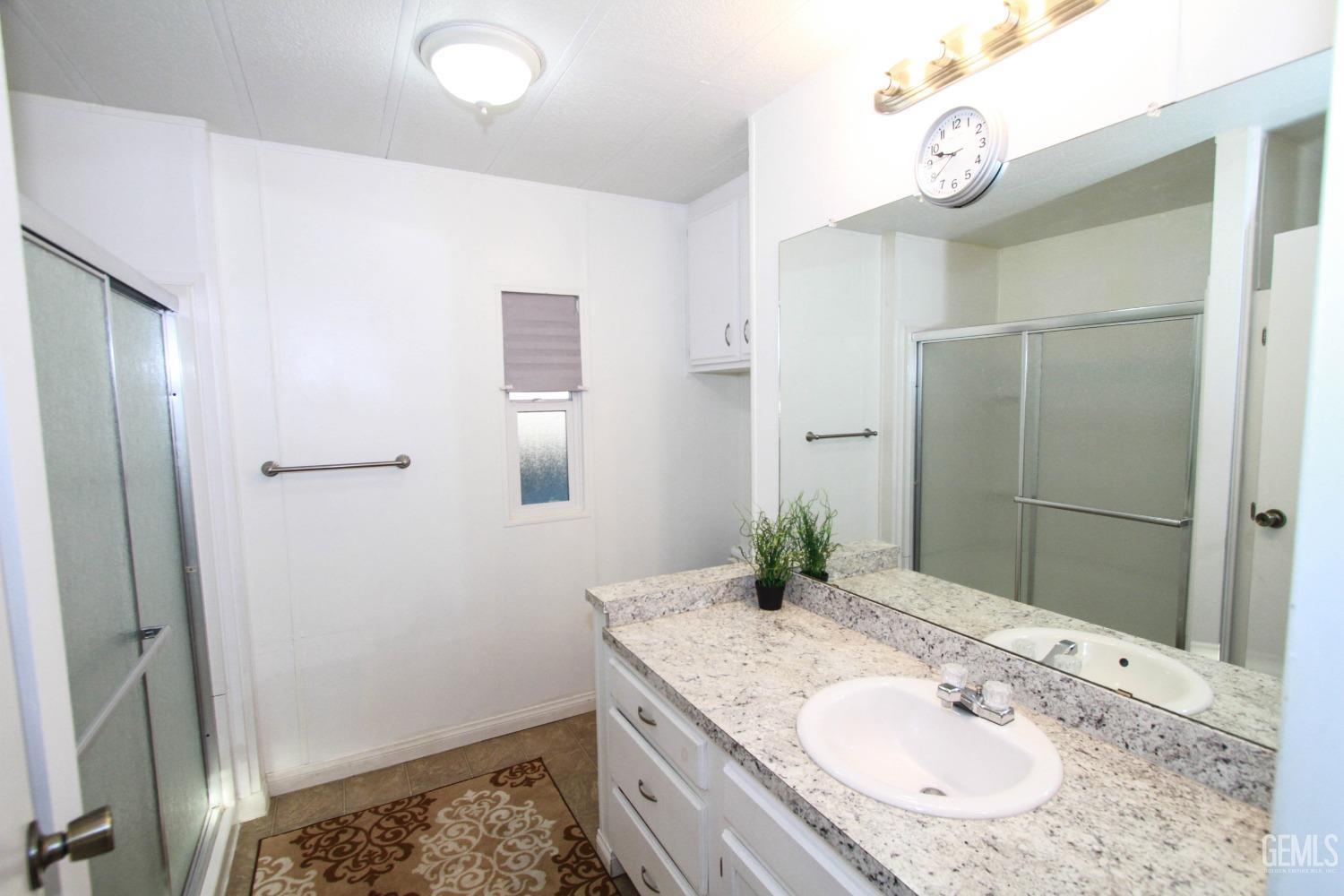 Undisclosed Address Bakersfield, CA 93301 - Photo 20 of 27 a bathroom with a granite countertop sink and a mirror