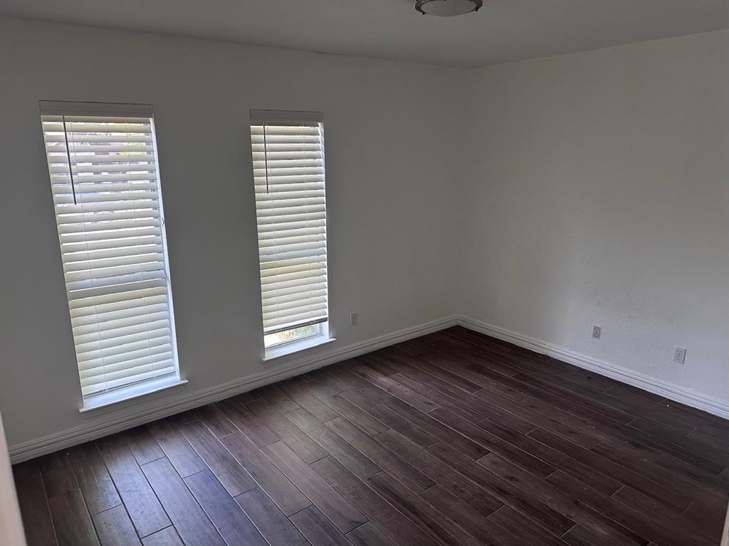 2103 Carlton Road Carrollton, TX 75007 - Photo 11 of 18 an empty room with wooden floor and windows