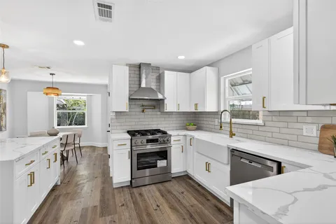 a kitchen with stainless steel appliances a white stove top oven sink and cabinets