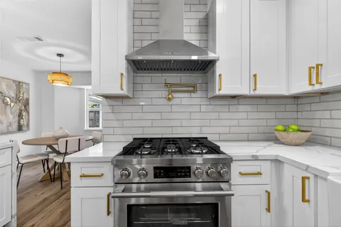 a kitchen with a stove a sink a refrigerator and cabinets