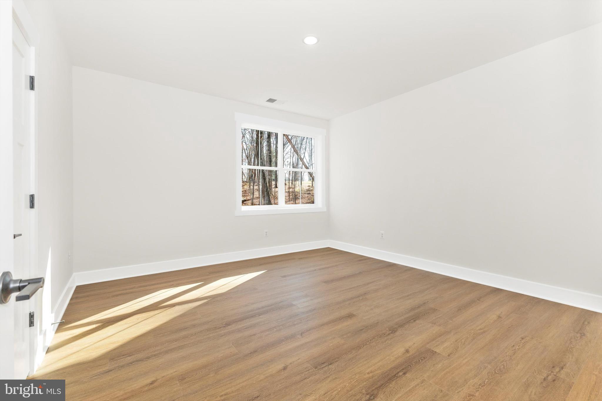 1199 Hoods Mill Road Cooksville, MD 21723 - Photo 45 of 86 an empty room with wooden floor and windows