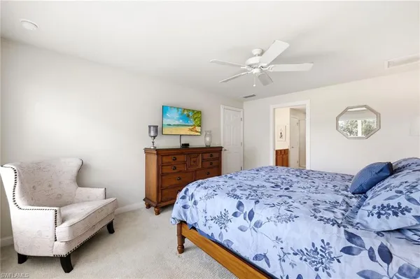 a spacious bedroom with a bed and a chandelier