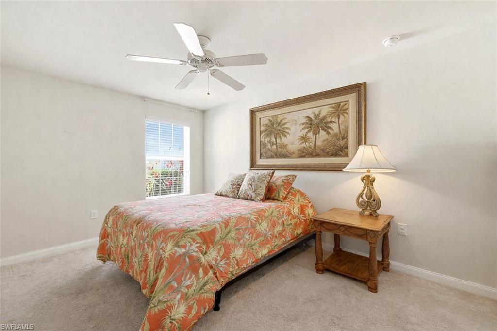 8664 Genova Court Naples, FL 34114 - Photo 15 of 46 a bedroom with a bed and a chandelier