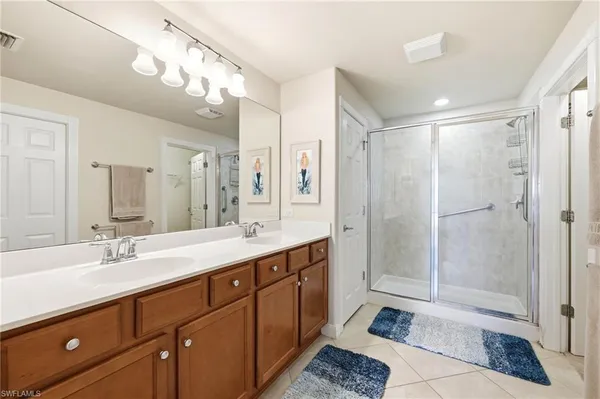 a bathroom with a double vanity sink mirror and shower