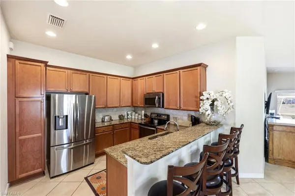 a kitchen with stainless steel appliances granite countertop a refrigerator sink and stove