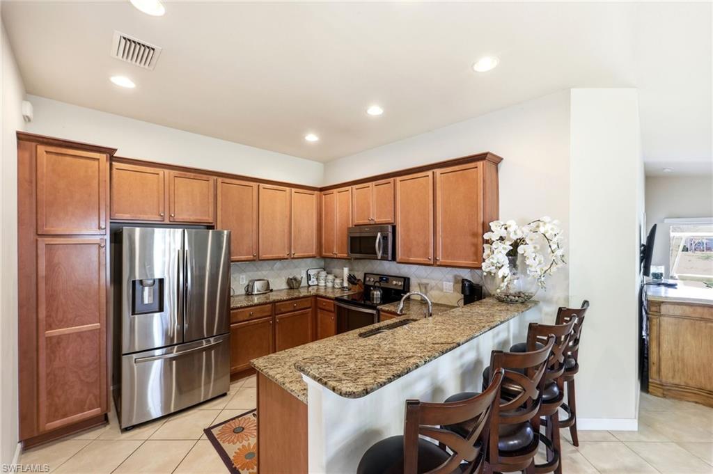 8664 Genova Court Naples, FL 34114 - Photo 4 of 46 a kitchen with stainless steel appliances granite countertop a refrigerator sink and stove
