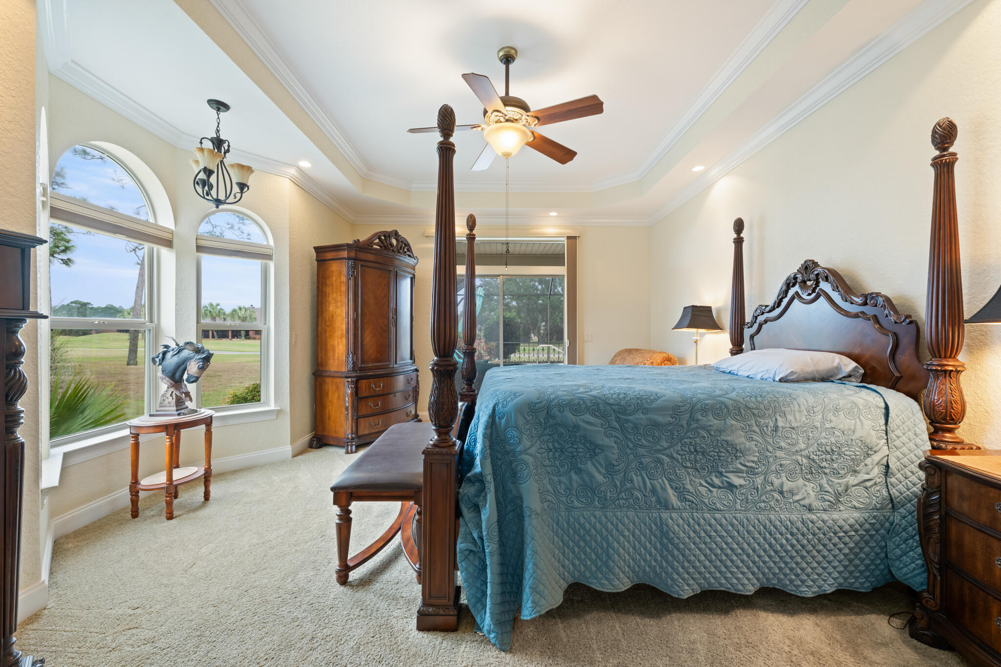 2615 Masters Boulevard Navarre, FL 32566 - Photo 19 of 51 a bedroom with a bed a chandelier and a large window