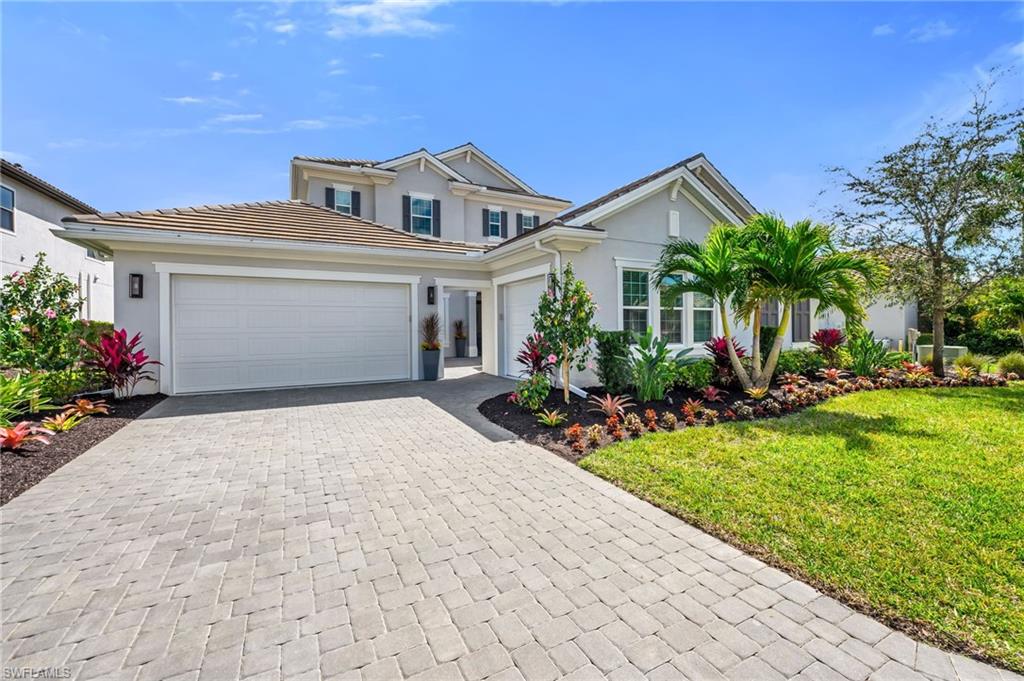 3410 Wellfleet Lane Naples, FL 34114 - Photo 1 of 28 a front view of a house with a yard and potted plants