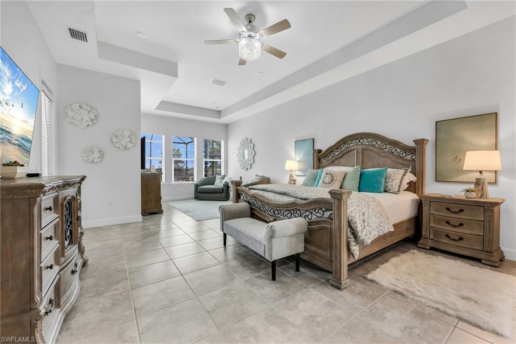 3410 Wellfleet Lane Naples, FL 34114 - Photo 11 of 28 a bedroom with a bed and a chandelier