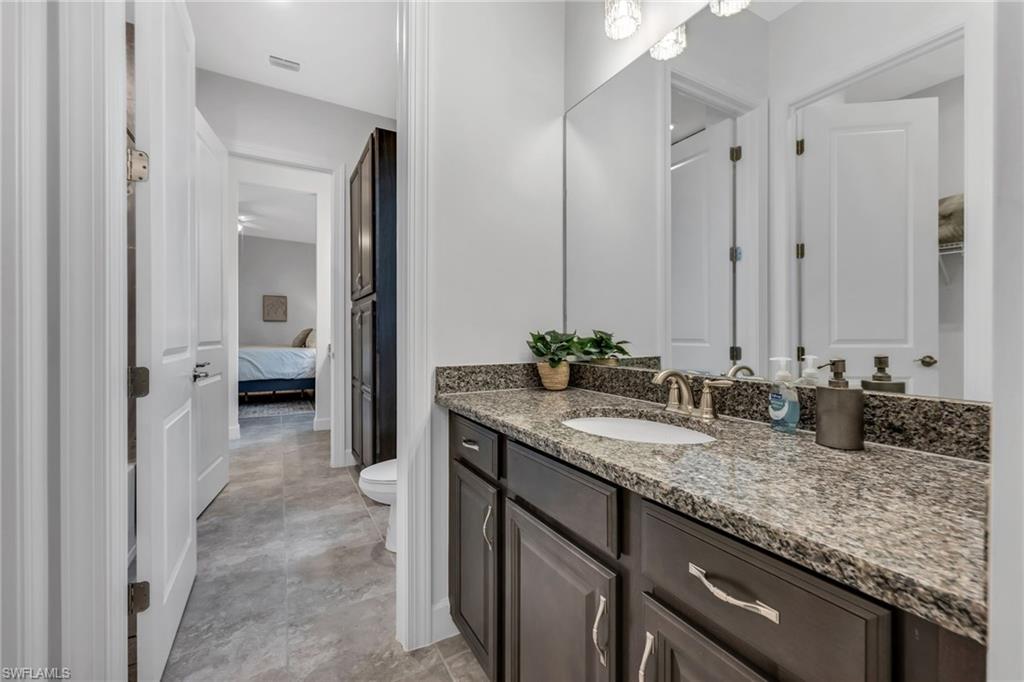 3410 Wellfleet Lane Naples, FL 34114 - Photo 18 of 28 a bathroom with a granite countertop sink and a mirror