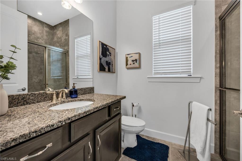3410 Wellfleet Lane Naples, FL 34114 - Photo 21 of 28 a bathroom with a granite countertop sink toilet and mirror