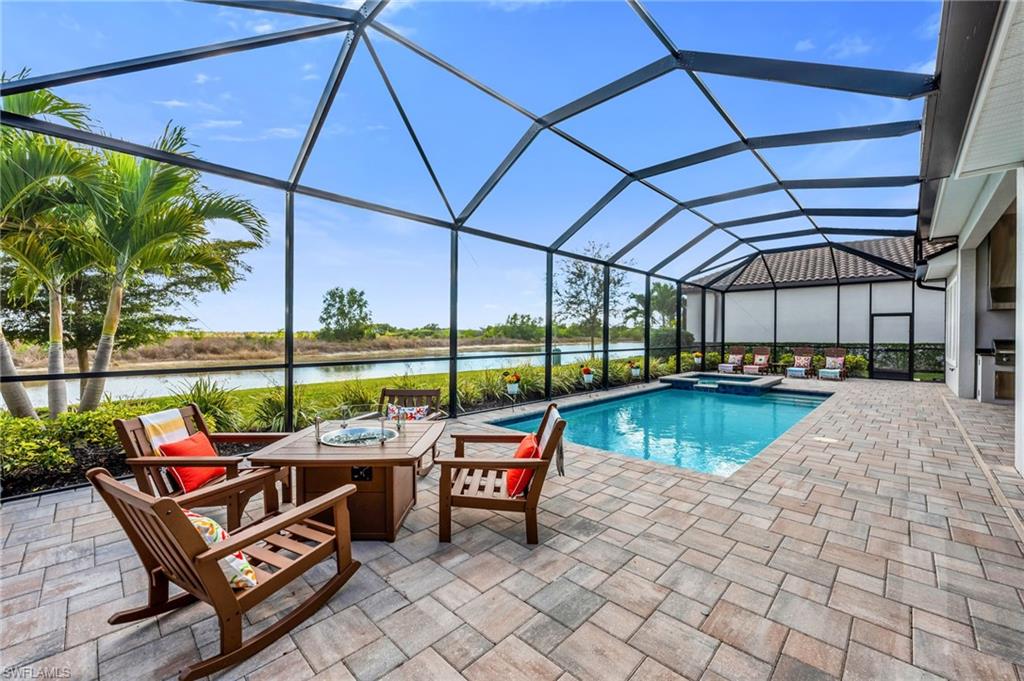 3410 Wellfleet Lane Naples, FL 34114 - Photo 23 of 28 a view of a patio with a table chairs and a swimming pool