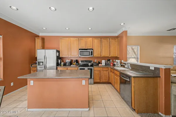 a kitchen with stainless steel appliances granite countertop a stove a sink and a refrigerator