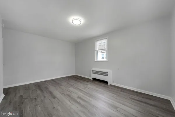 a view of a livingroom with wooden floor and a window