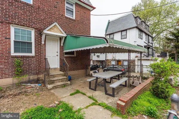 a couple of table and chairs in front of house