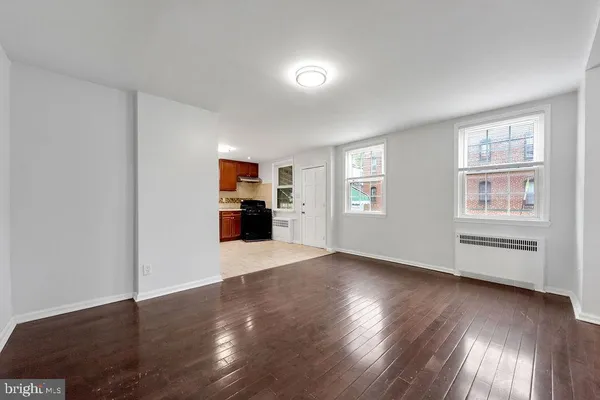a view of empty room with wooden floor and window