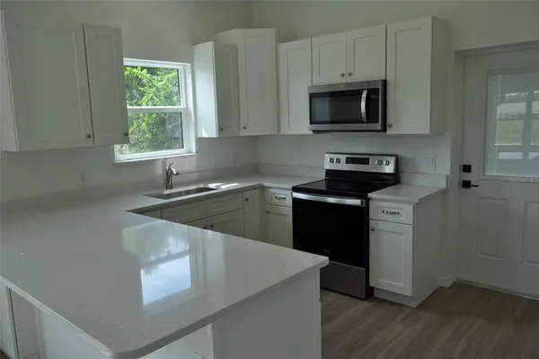 a kitchen with a stove a sink and a microwave