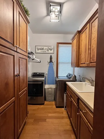 a kitchen with stainless steel appliances granite countertop a refrigerator a sink dishwasher a stove with wooden cabinets and floor