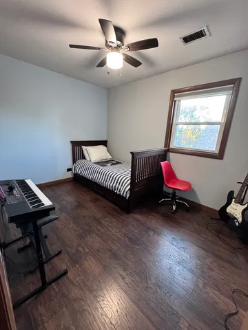 a bedroom with bed and wooden floor