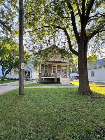 a front view of a house with swimming pool having outdoor seating