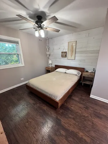 a bedroom with a bed window and a flat screen tv
