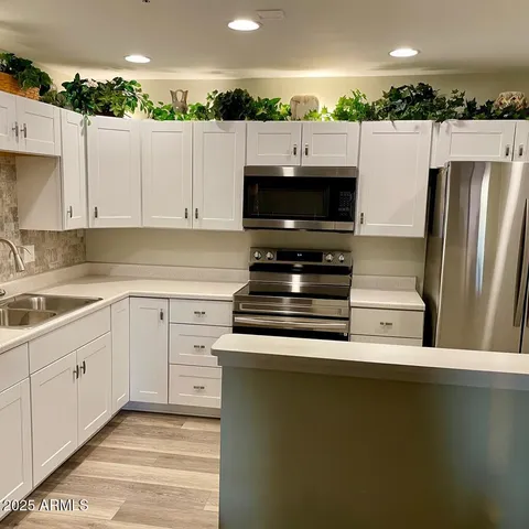 a kitchen with a refrigerator sink and cabinets