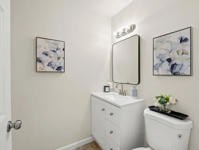 a bathroom with a double vanity sink mirror and toilet