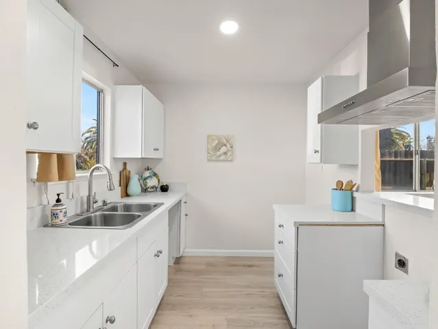 a kitchen with granite countertop a sink stove and cabinets
